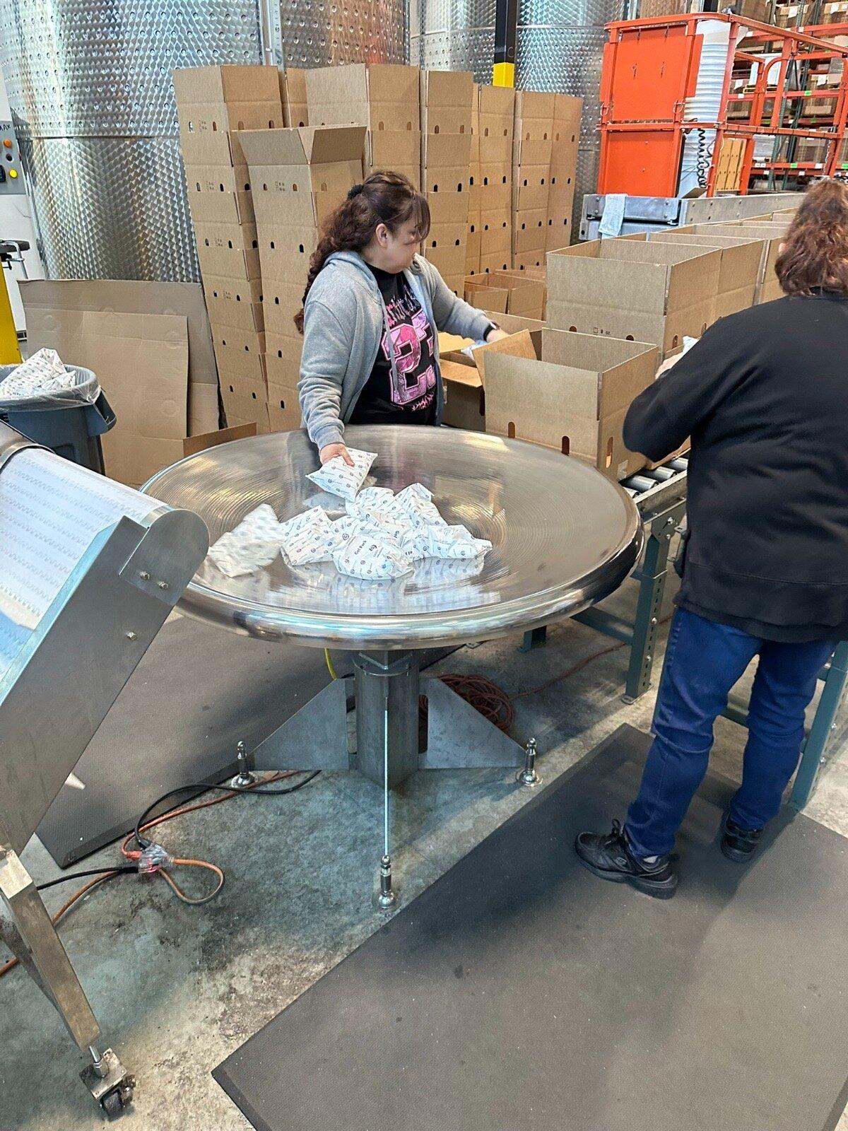 Workers preparing cold-chain shipments at a production station